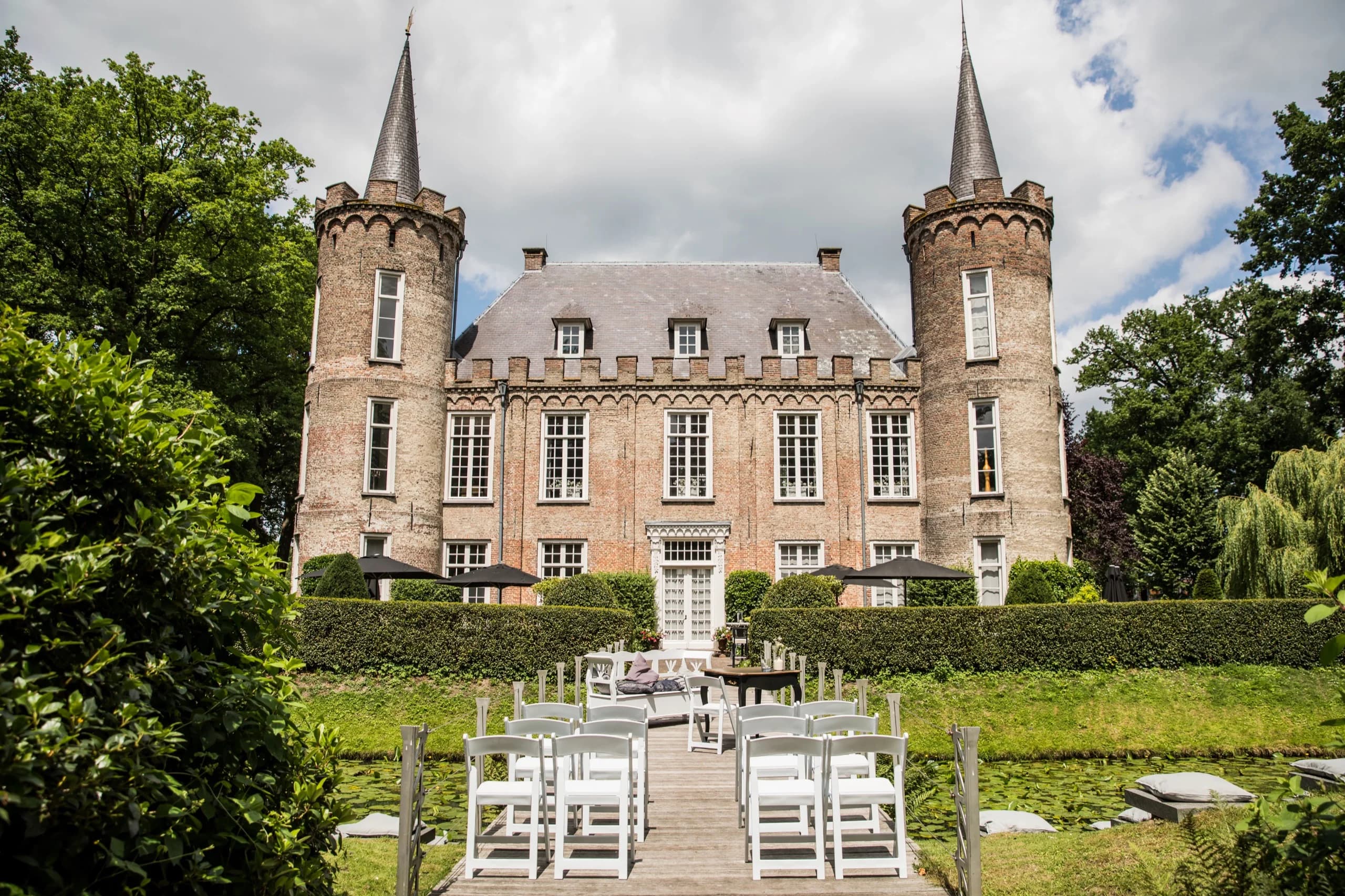 Kasteel Henkenshage gezien vanaf het water, met witte stoelen opgesteld op de vlonder voor de ceremonie